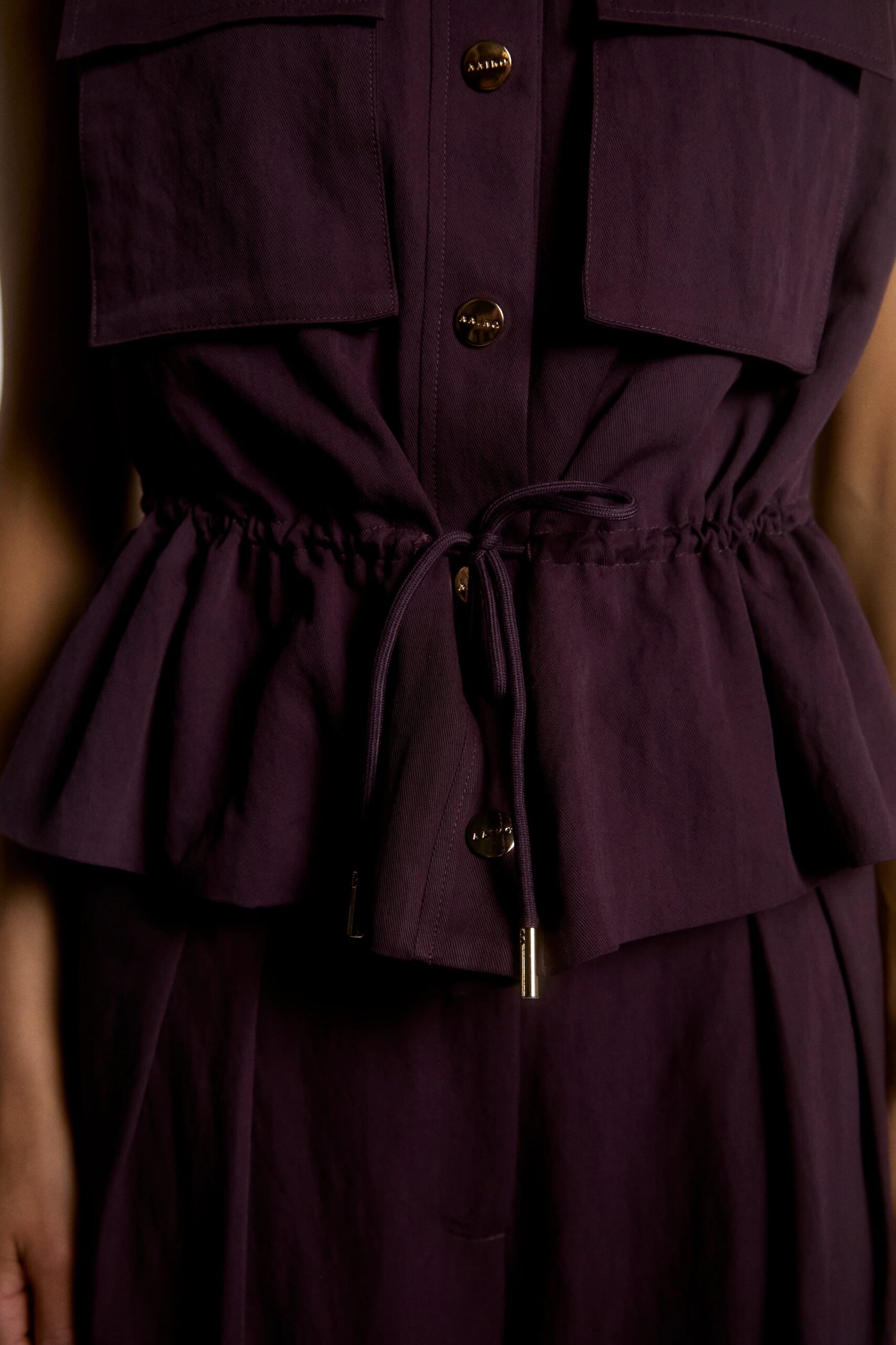 Detail van Aaiko Lena gilet paars met knopen en taillekoord